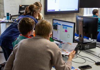 Facilitator guiding parent and child through OurKidsCode workshop