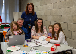 Facilitator with families working on creative coding